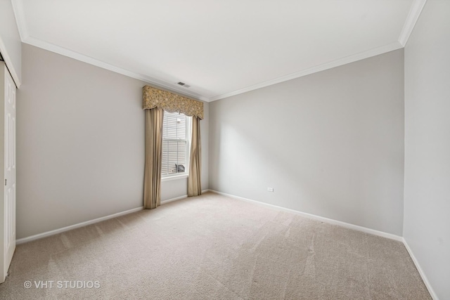 carpeted empty room with baseboards, visible vents, and ornamental molding