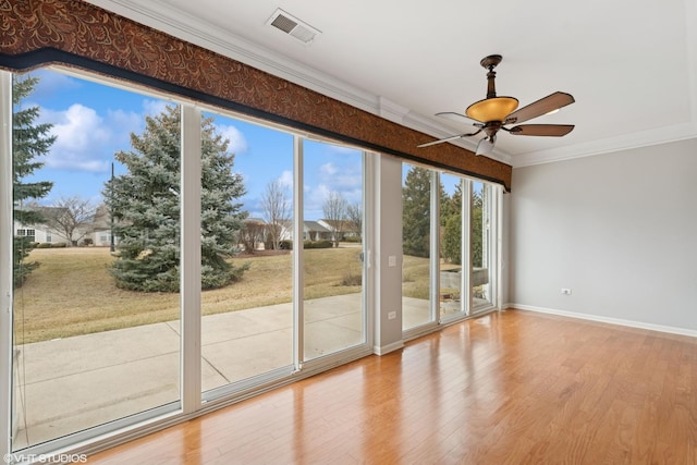 entryway featuring ceiling fan, wood finished floors, visible vents, baseboards, and ornamental molding