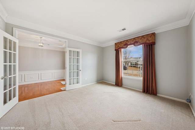 carpeted spare room featuring baseboards, visible vents, ornamental molding, and french doors