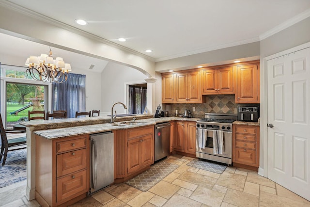 kitchen featuring arched walkways, appliances with stainless steel finishes, a peninsula, stone tile flooring, and a sink