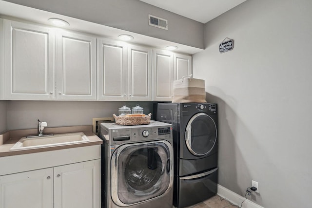 laundry room featuring separate washer and dryer, a sink, visible vents, baseboards, and cabinet space