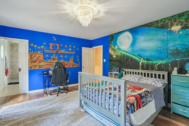 bedroom with an inviting chandelier, baseboards, and wood finished floors