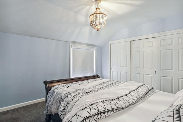 bedroom featuring lofted ceiling, a notable chandelier, baseboards, a closet, and dark colored carpet