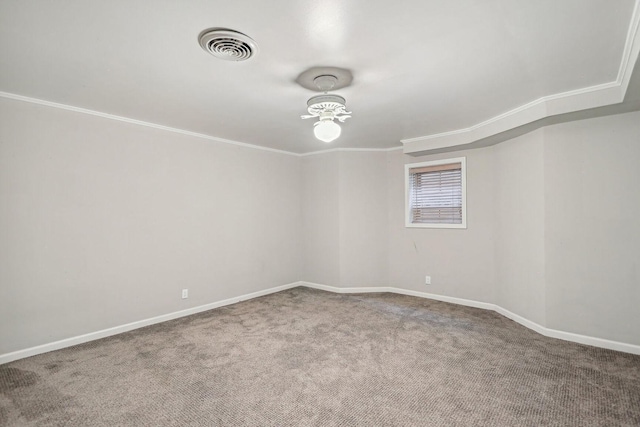 carpeted spare room featuring visible vents, crown molding, and baseboards