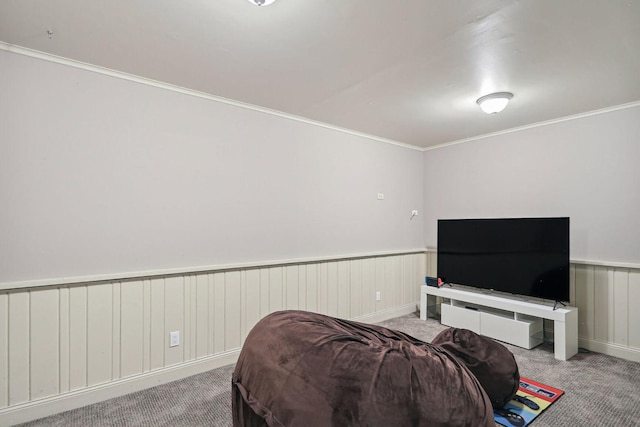 bedroom featuring a wainscoted wall, crown molding, and light colored carpet