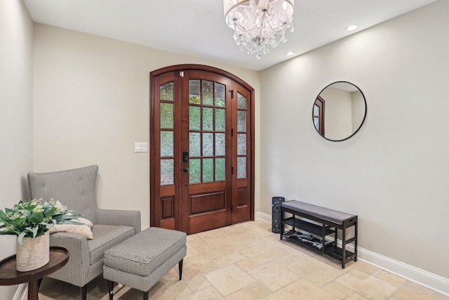 entrance foyer with an inviting chandelier, stone tile floors, baseboards, and recessed lighting