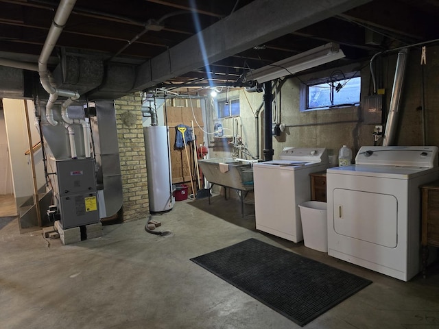 basement with a sink, heating unit, water heater, and washing machine and clothes dryer