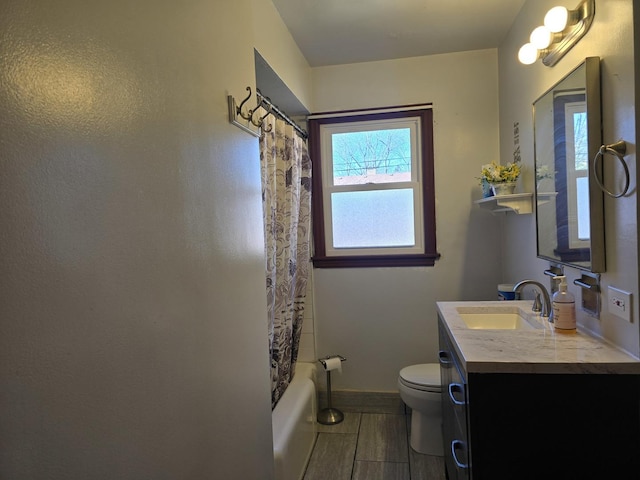 bathroom with toilet, vanity, baseboards, and shower / bath combo