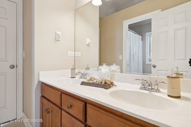 full bathroom with a sink and double vanity