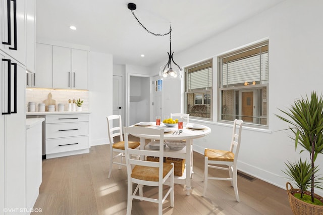 dining area featuring light wood finished floors, baseboards, and recessed lighting