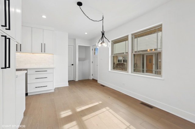 unfurnished dining area featuring light wood-style flooring, recessed lighting, visible vents, and baseboards