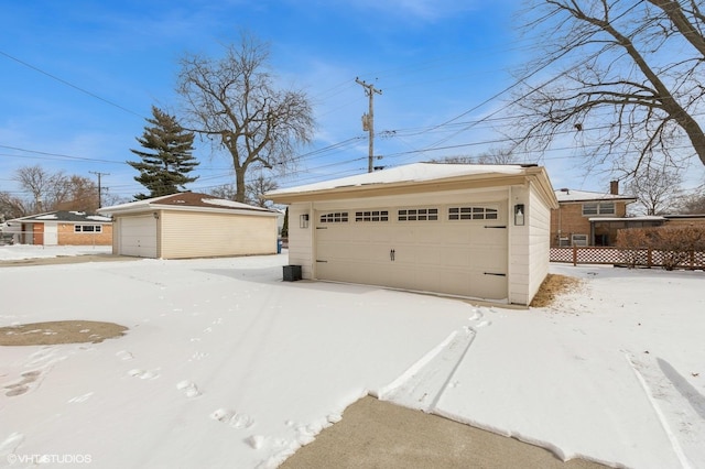 snow covered garage featuring a garage