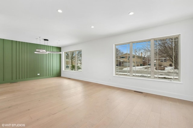 empty room with baseboards, light wood-style flooring, visible vents, and recessed lighting