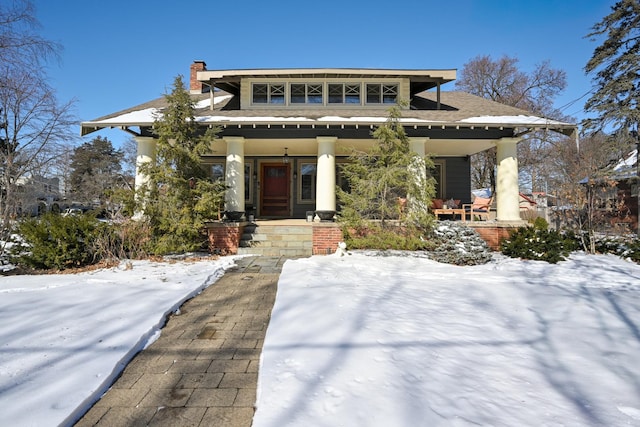 view of front of house with covered porch and a chimney