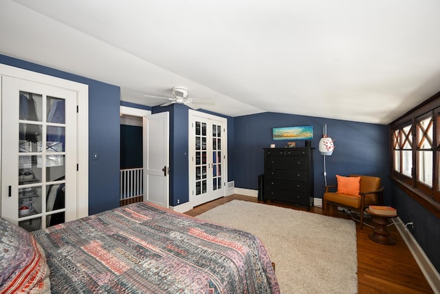 bedroom featuring french doors, vaulted ceiling, baseboards, and wood finished floors