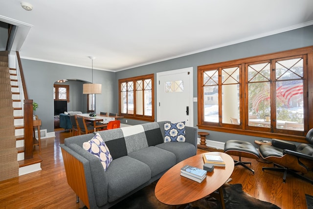 living room with ornamental molding, wood finished floors, and baseboards