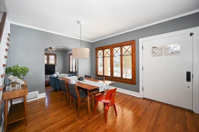 dining area with crown molding, baseboards, and wood finished floors