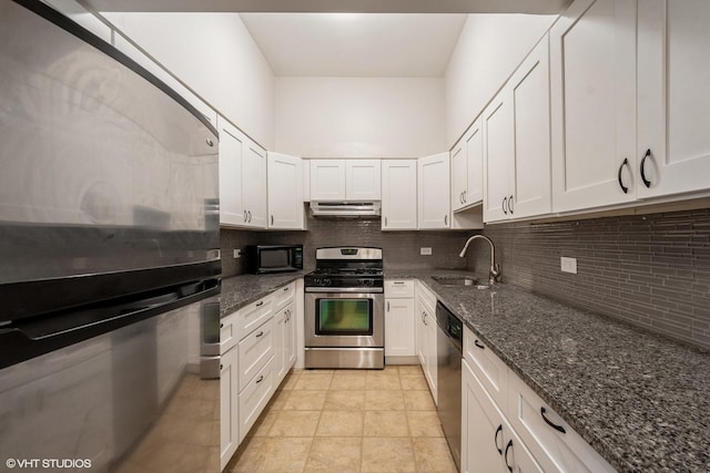 kitchen with stainless steel gas range oven, white cabinets, under cabinet range hood, black microwave, and a sink