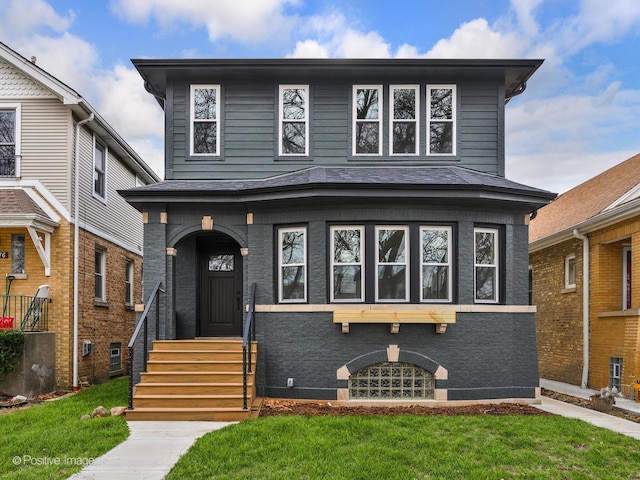 american foursquare style home with a front yard