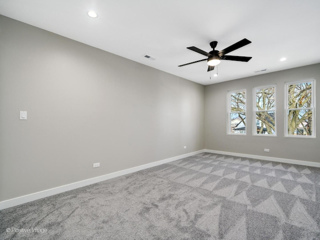 unfurnished room with a ceiling fan, light carpet, visible vents, and baseboards