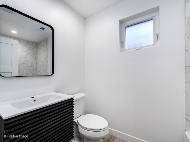 bathroom with visible vents, baseboards, toilet, wood finished floors, and vanity