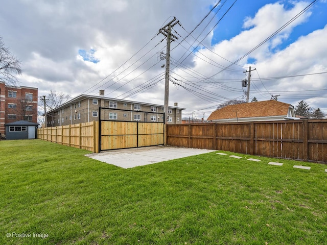 view of yard with an outbuilding, a patio area, fence, and a storage shed