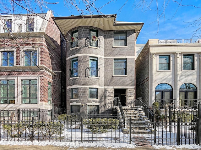 view of front of property featuring a fenced front yard and brick siding