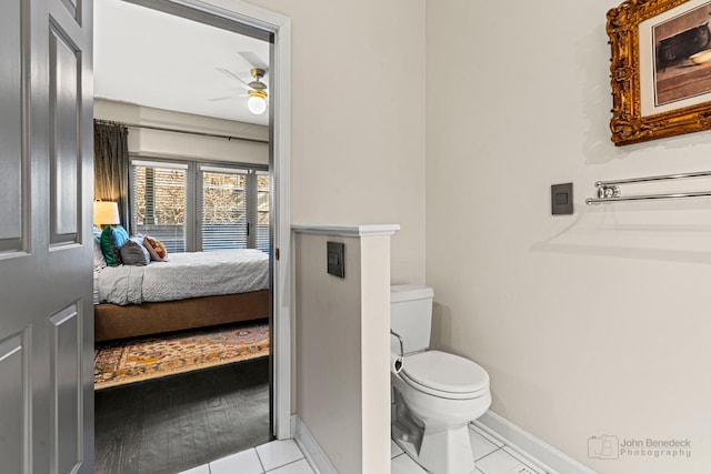 ensuite bathroom with a ceiling fan, baseboards, toilet, and ensuite bath