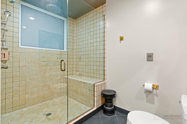 full bath featuring baseboards, a shower stall, toilet, and tile patterned floors