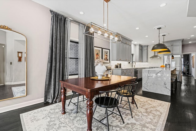 dining area featuring baseboards, dark wood finished floors, and recessed lighting