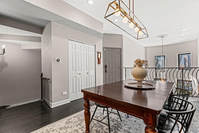 dining space with a chandelier, dark wood-style flooring, and baseboards