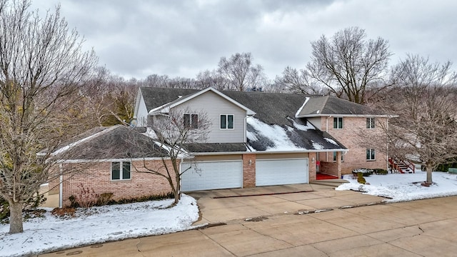 view of front of house featuring driveway, a garage, and brick siding