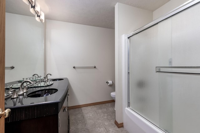 full bath with combined bath / shower with glass door, a sink, toilet, and double vanity