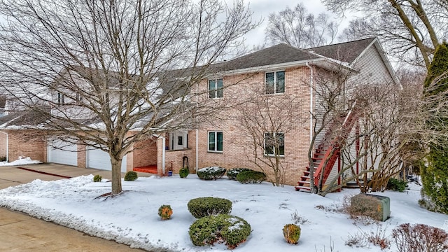 view of front of property with driveway, brick siding, and an attached garage