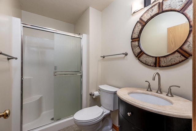 bathroom featuring a stall shower, vanity, and toilet