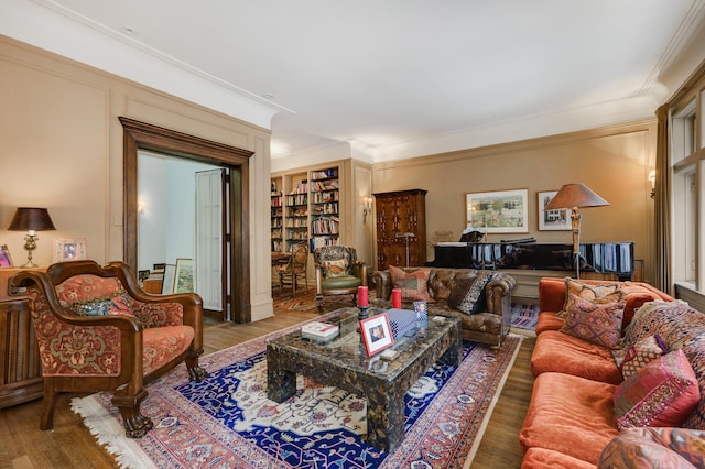 living room with ornamental molding, wood finished floors, and built in shelves