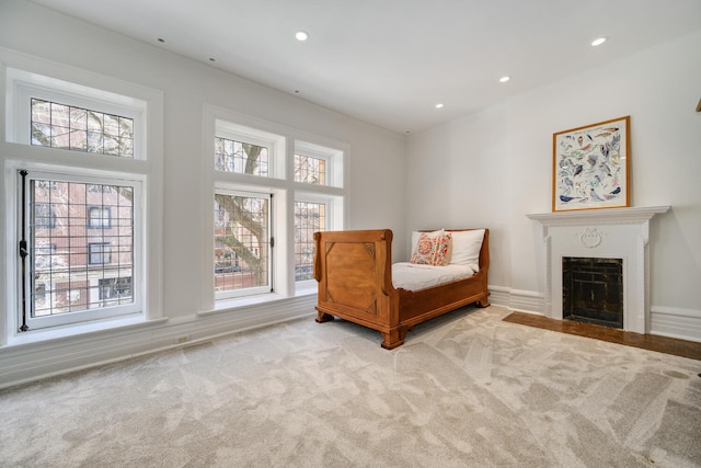 living area featuring light carpet, a fireplace with flush hearth, and recessed lighting