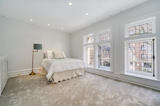 bedroom with baseboards, recessed lighting, and light colored carpet