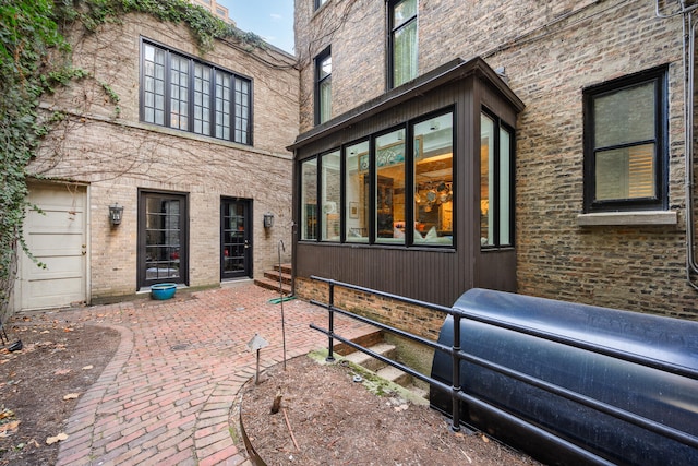 view of side of home with a patio area and brick siding