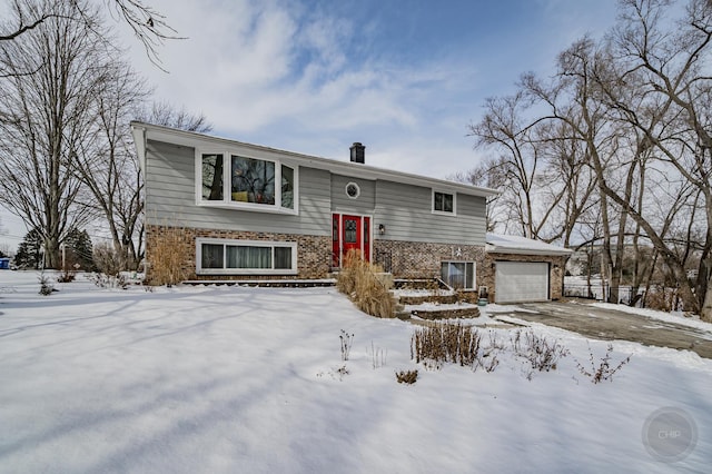 raised ranch with a garage and brick siding