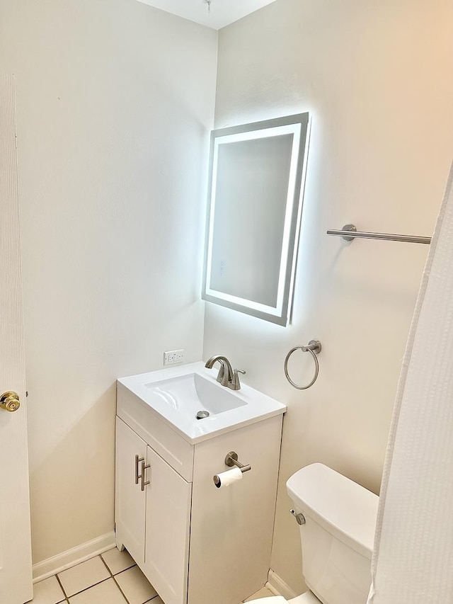 bathroom with tile patterned flooring, vanity, toilet, and baseboards