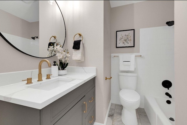 full bathroom with marble finish floor, vanity, washtub / shower combination, and toilet