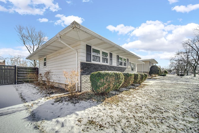 view of snowy exterior featuring fence