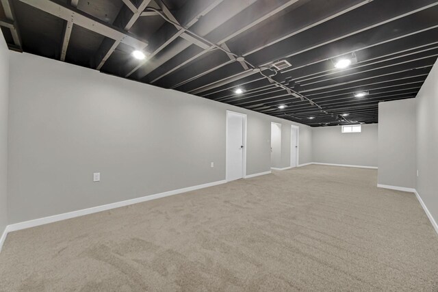 finished below grade area with baseboards and carpet flooring