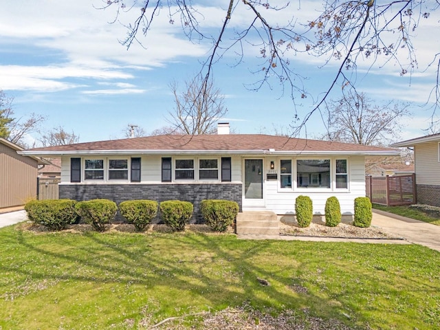 ranch-style home with fence, a chimney, and a front yard
