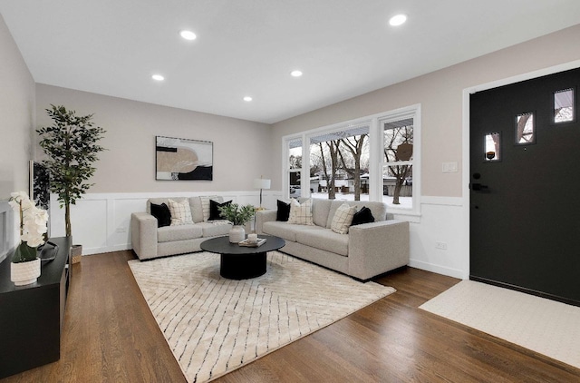 living room featuring a wainscoted wall, dark wood-type flooring, a decorative wall, and recessed lighting