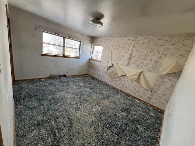 unfurnished room featuring carpet flooring and baseboards