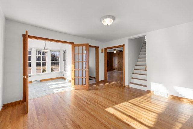 entryway featuring visible vents, a ceiling fan, wood finished floors, stairway, and baseboards