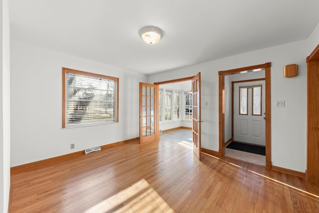 entrance foyer with a wealth of natural light, visible vents, baseboards, and light wood-style floors