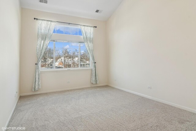 spare room featuring carpet floors, baseboards, and visible vents